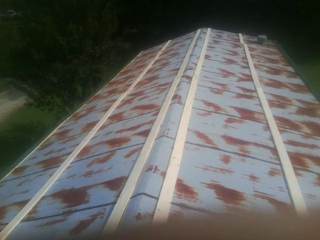 Rusted metal roof panels with new wood purlins before replacement — Storm Damage Roof Repair in Dearborn by Roofing Brothers