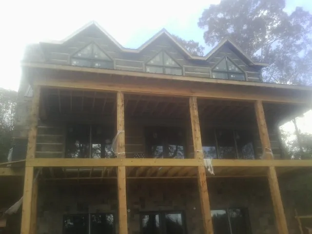 Dormers and porch framing on a large log home under construction — Roof Coating work by our crew in Dearborn